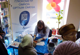 Медсестра проверяла уровень сахара крови глюкометром OMRON Optium Omega, параллельно давая консультации