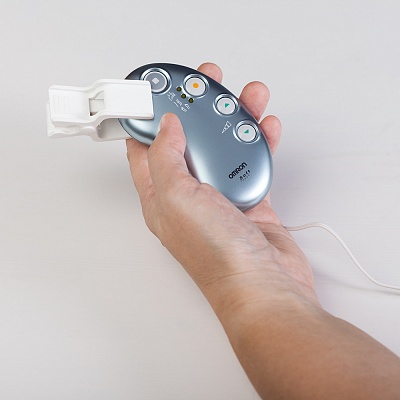 
                Миостимулятор OMRON Soft Touch, прибор и клипса в руке